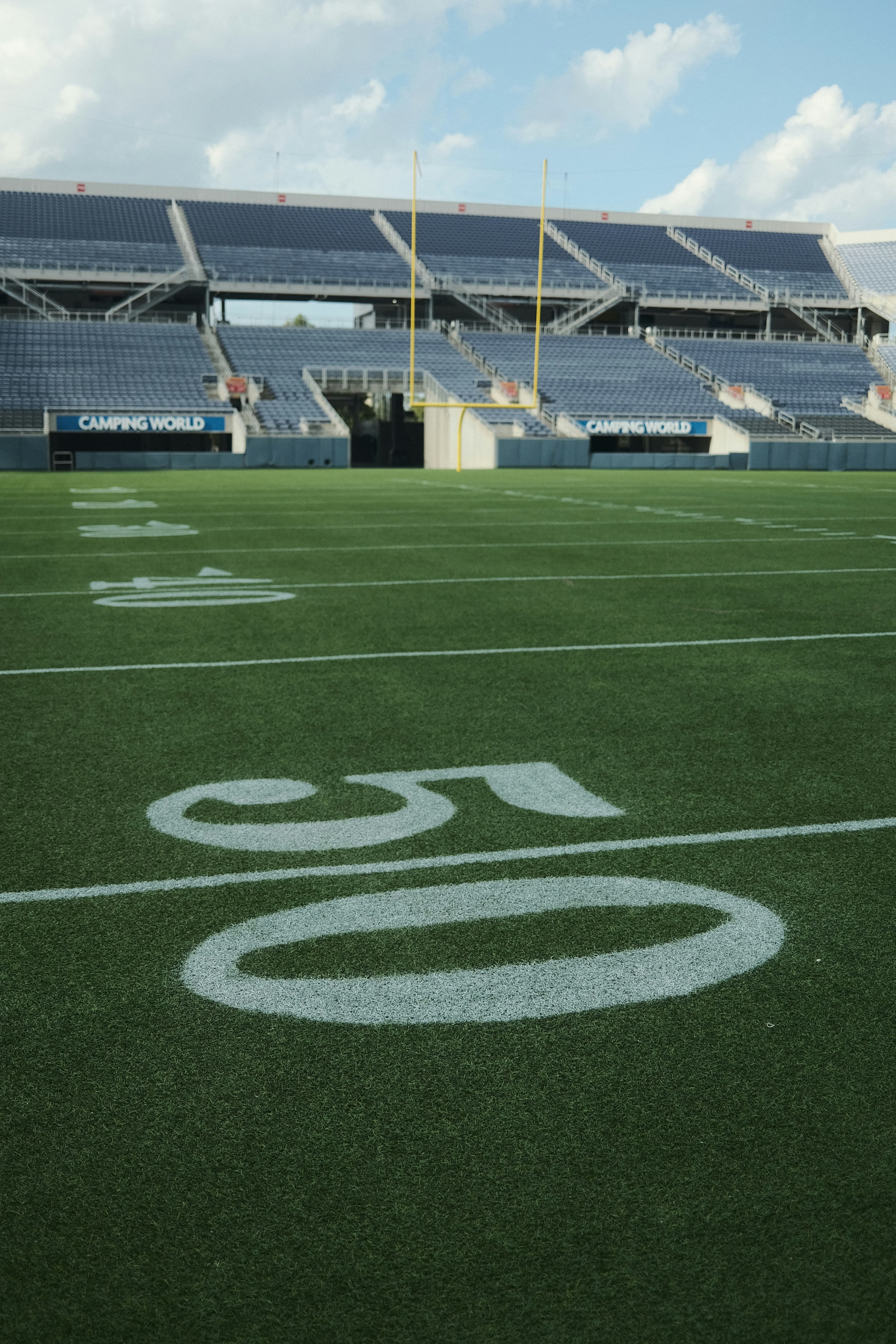 An empty football field under the sky. Photo by Patrick Konior on Unsplash